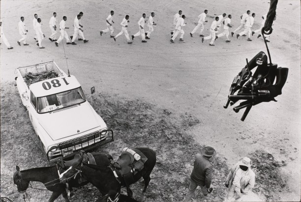 Guns are passed to the picket tower; the line returns from work
