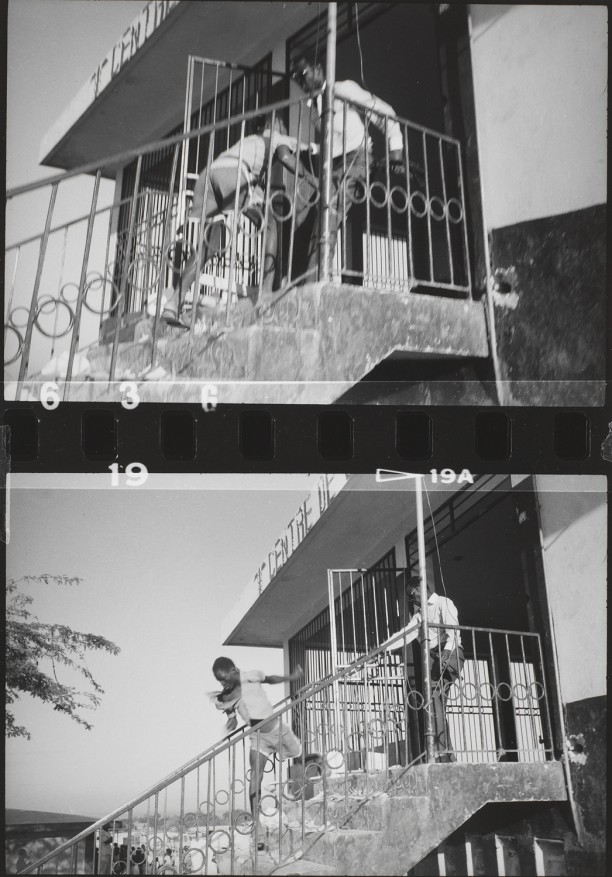 An out-of-uniform Tonton Macoute throws looter down a flight of stairs
