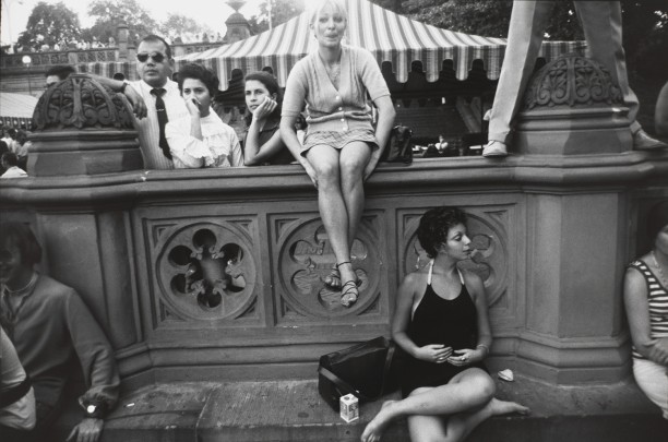 Untitled (Blond woman in v-neck sweater, sitting on wall)